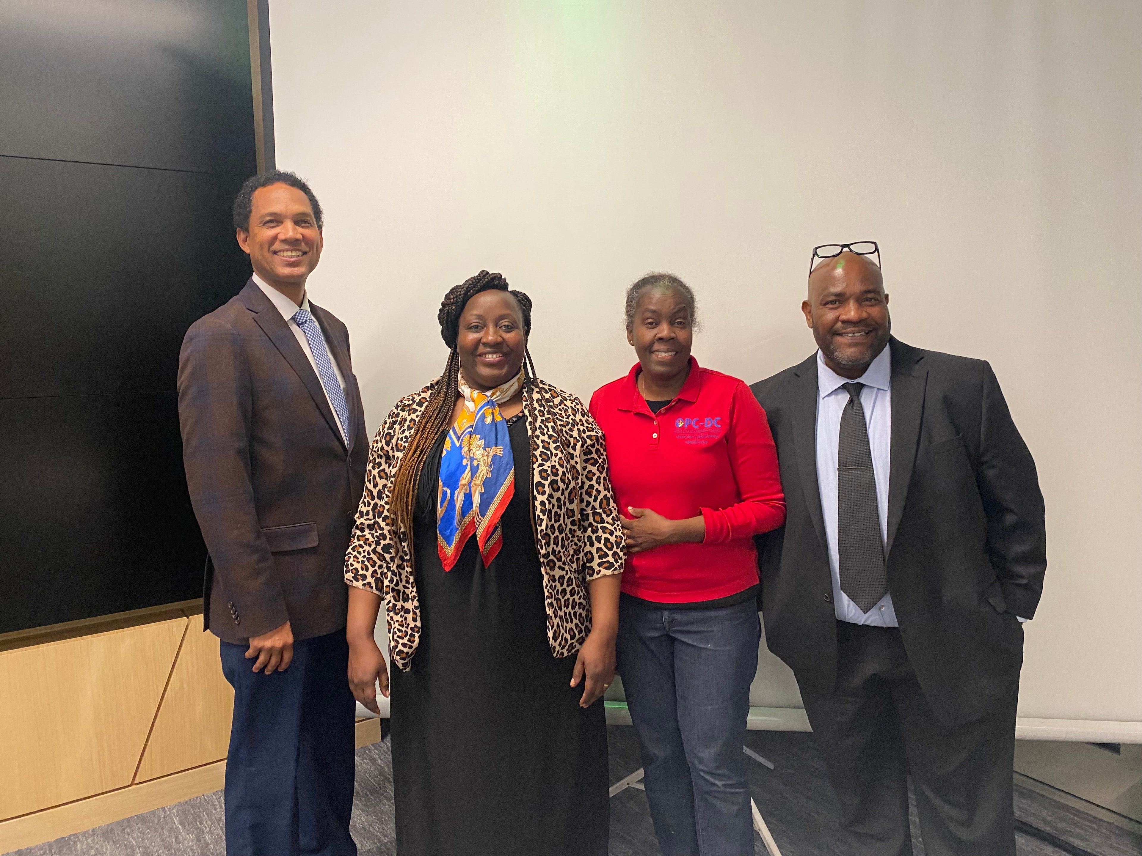 Four professionals posing together at a community event
